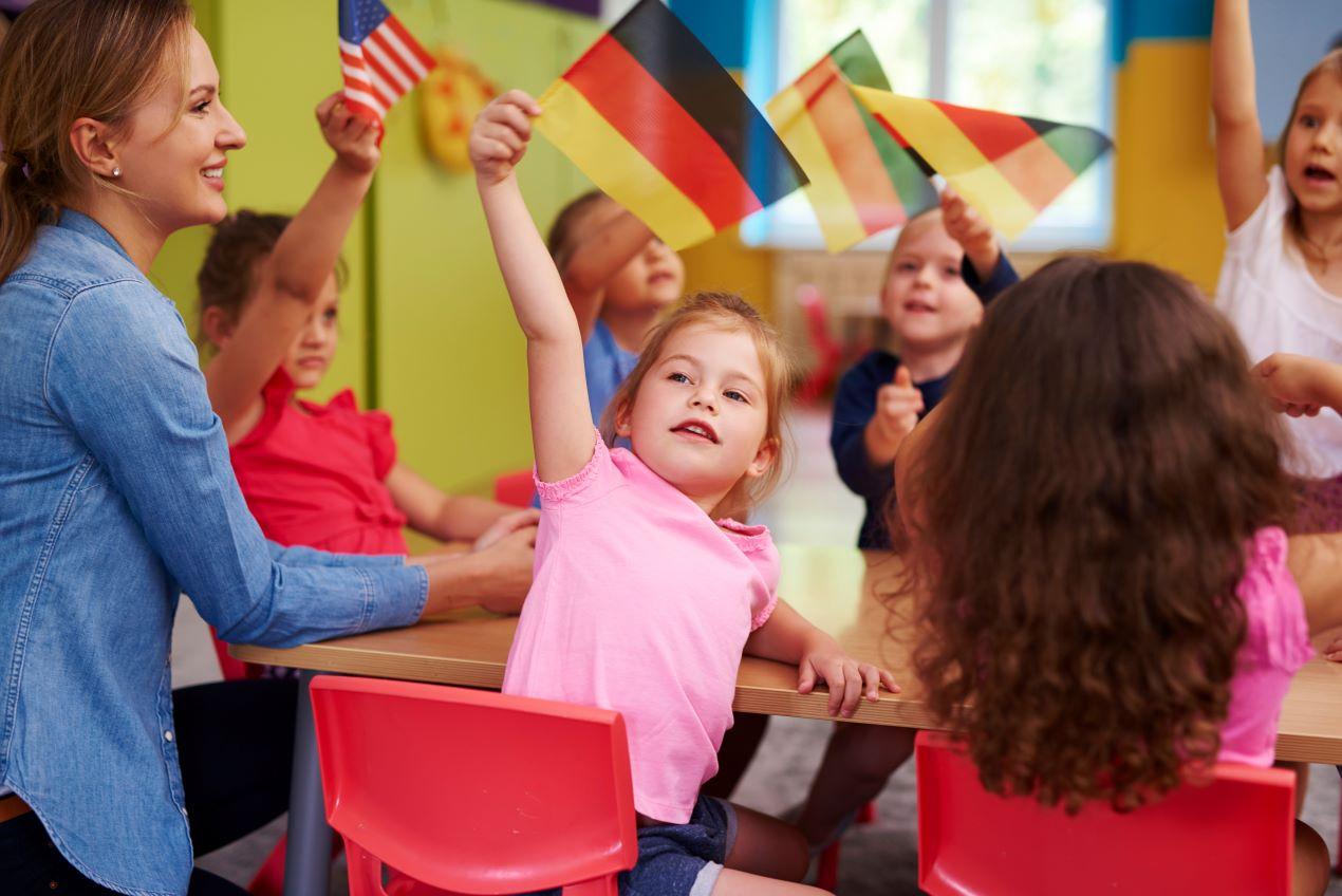 Kinder im Klassenzimmer mit deutschen und amerikanischen Flaggen – Berlin bilinguale Grundschule für zweisprachige Bildung