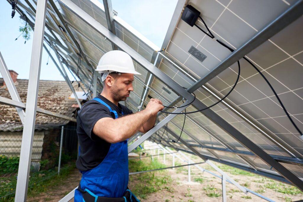 Ein Techniker installiert Solarpanels für ein SMA Hybrid-System, das erneuerbare Energien effizient nutzt.